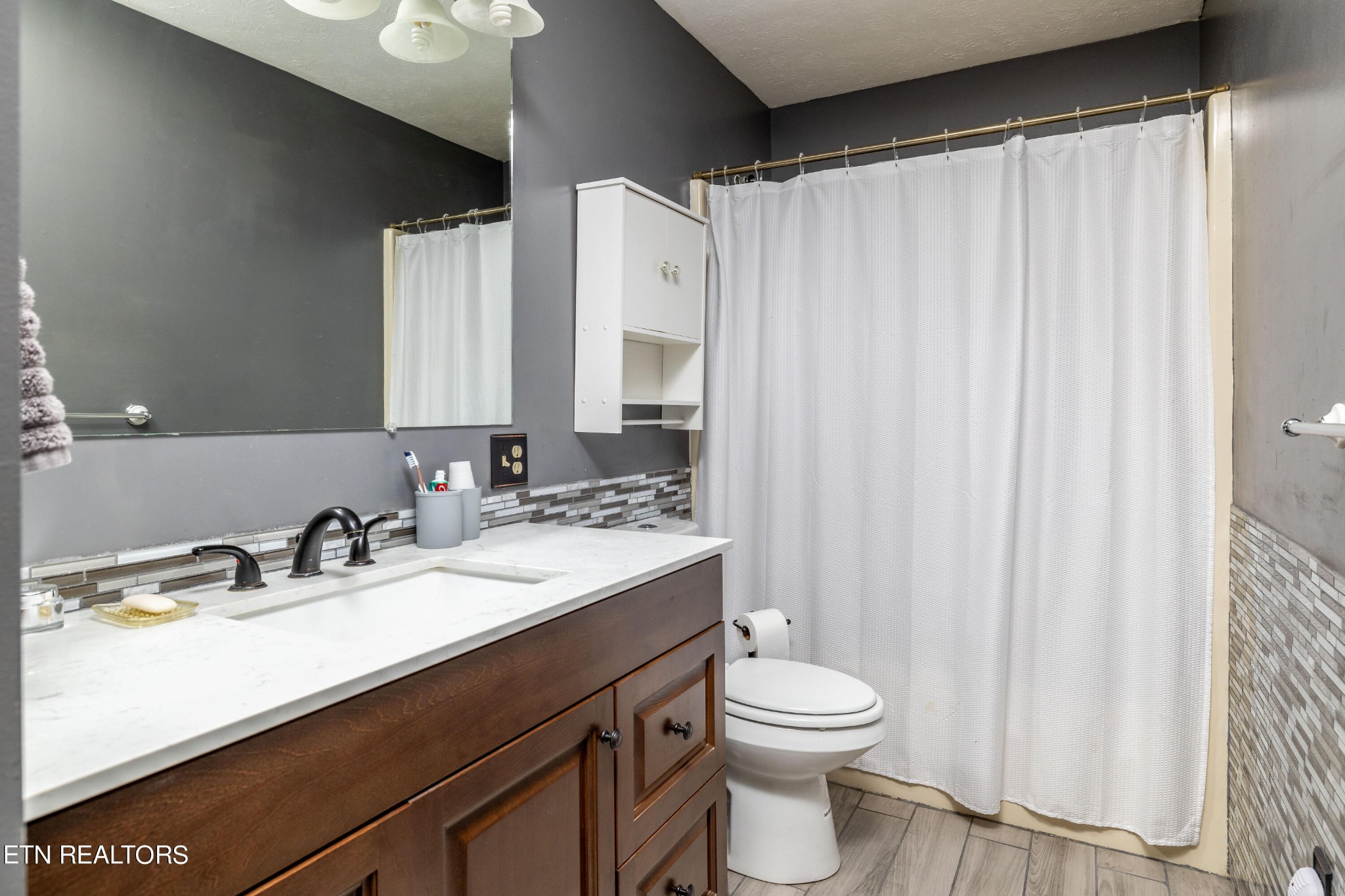 929 Robinson Gap Road Sevierville, TN 37876 - Photo 18 of 28 a bathroom with a sink a toilet and shower curtain