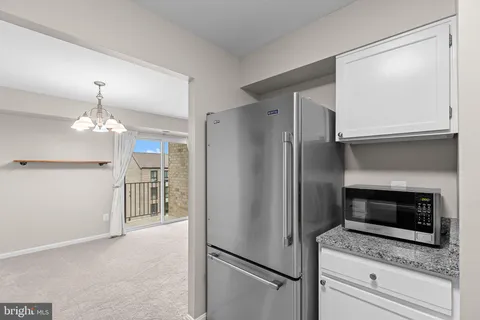 a kitchen with a refrigerator and a stove top oven