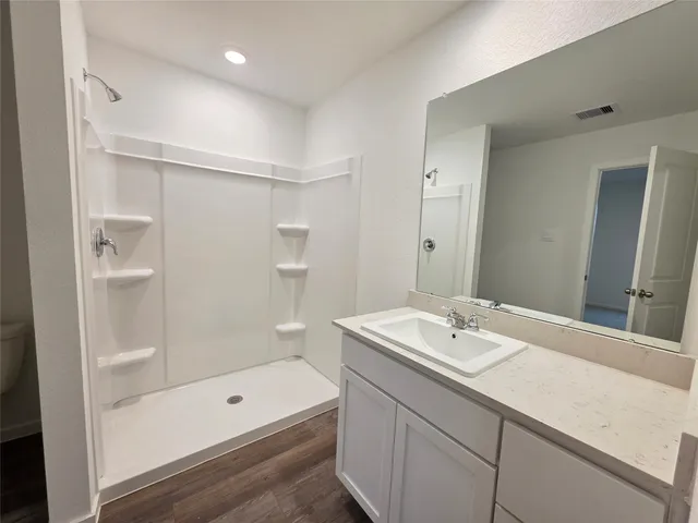 a bathroom with a bath tub sink mirror and a shower