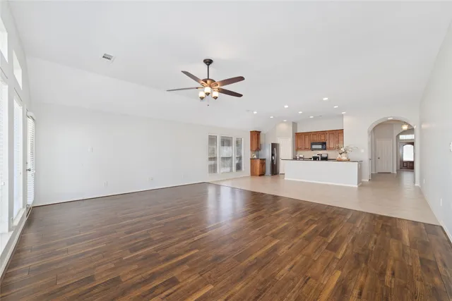 a view of a living room a wooden floor and a ceiling fan