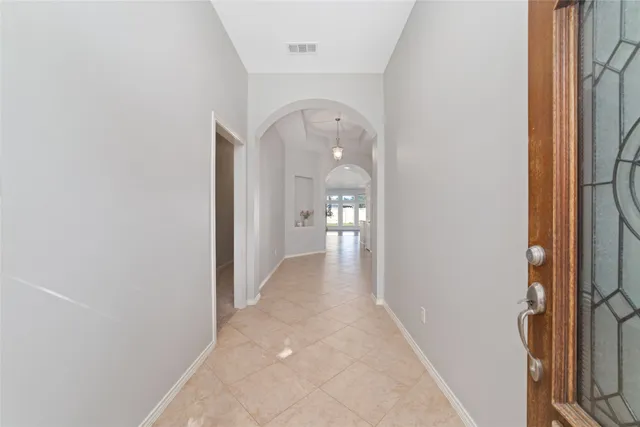 a view of a hallway with a livingroom and a window