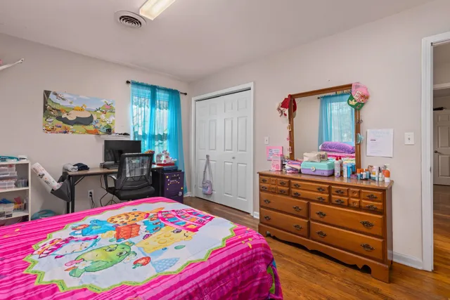 a bedroom with a bed and a dresser in it