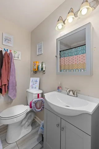 a bathroom with a sink mirror vanity and toilet