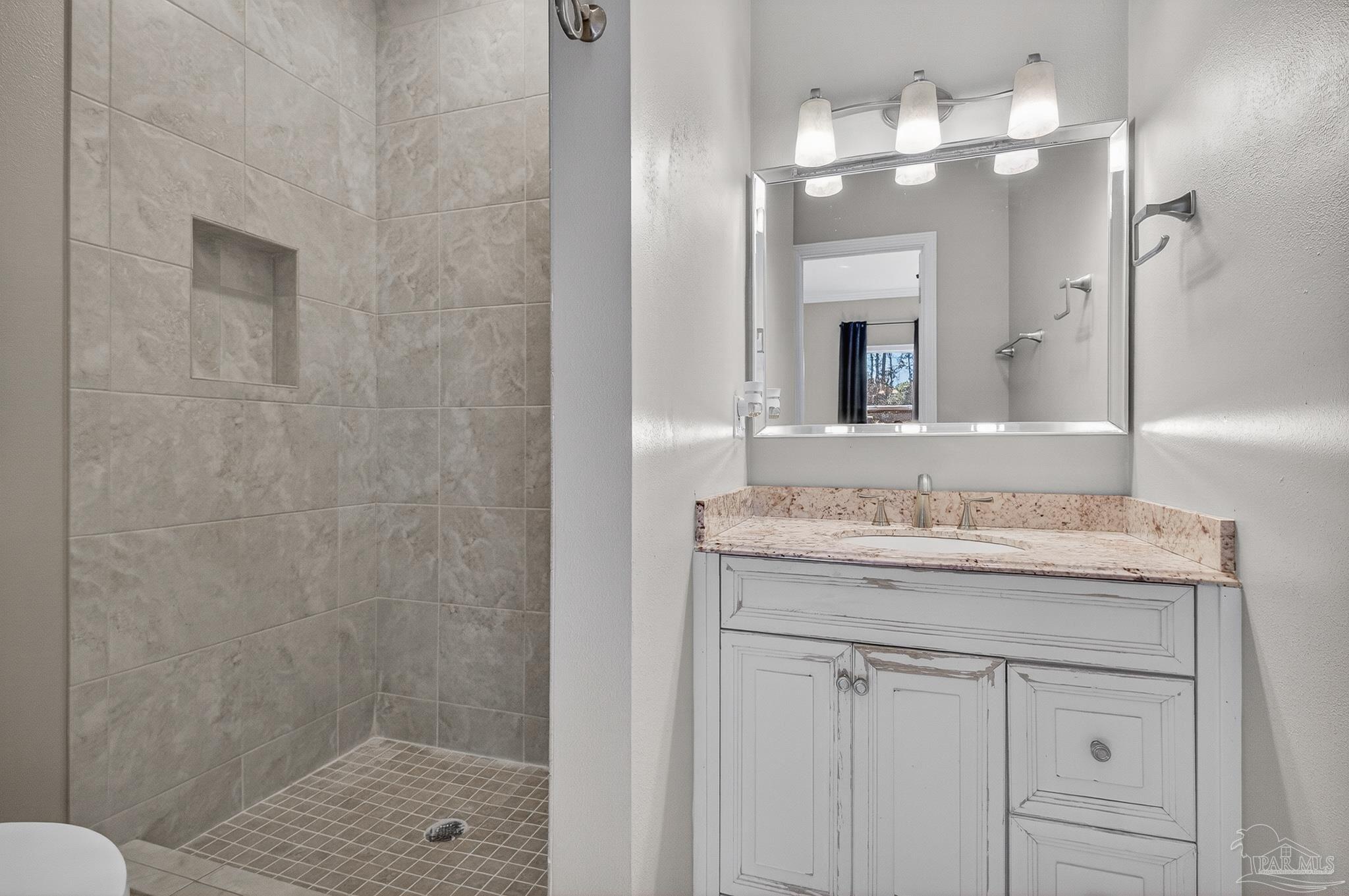 16360 Innerarity Point Road Pensacola, FL 32507 - Photo 23 of 56 a bathroom with a granite countertop sink a toilet and a mirror