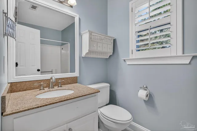 a bathroom with a granite countertop sink a mirror and a shower