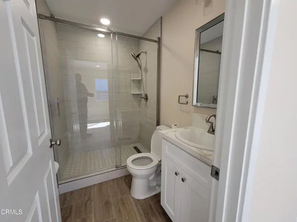 a bathroom with a granite countertop toilet a sink and a shower