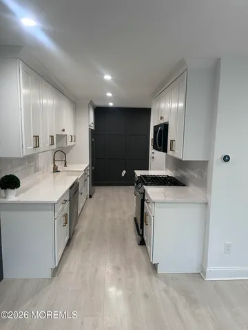 a kitchen with a sink stove and cabinets