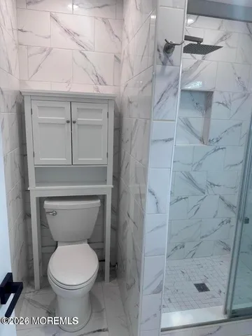a bathroom with a toilet and a shower