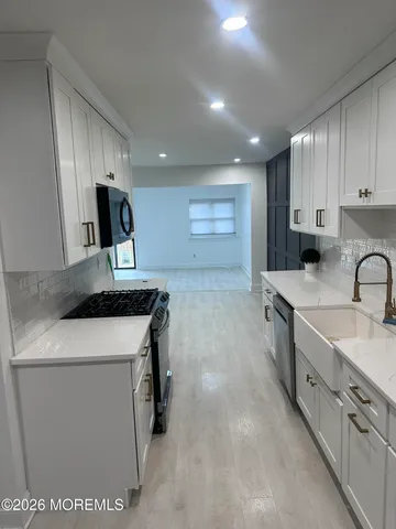 a kitchen with stainless steel appliances granite countertop a sink a stove and a refrigerator