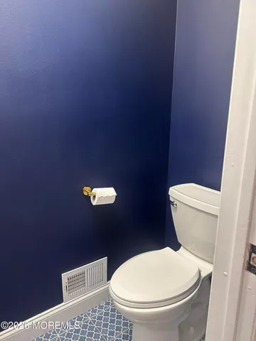 a white toilet sitting next to a white wall