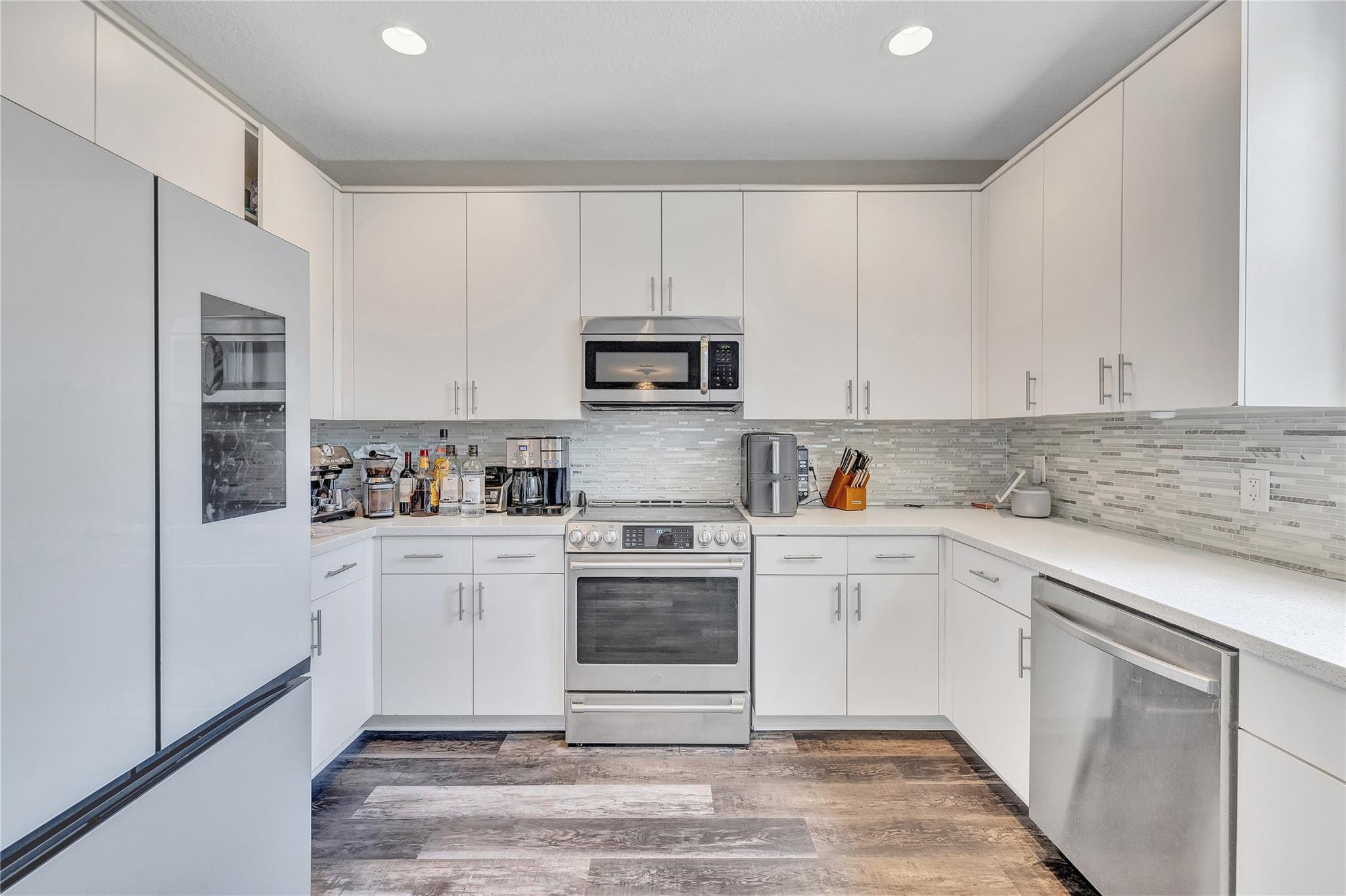 18219 Blue Lake Way Boca Raton, FL 33498 - Photo 14 of 39 a kitchen with granite countertop white cabinets and stainless steel appliances