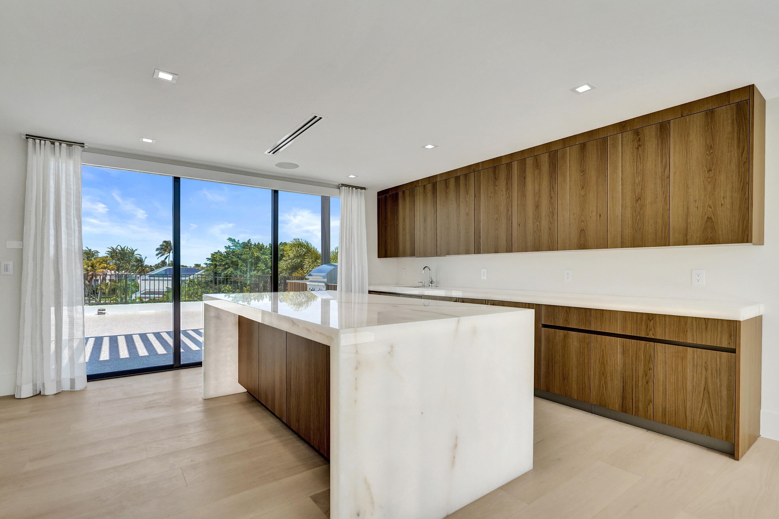 365 Northeast 3rd Street Boca Raton, FL 33432 - Photo 20 of 41 a kitchen with stainless steel appliances granite countertop a refrigerator a sink and wooden cabinets