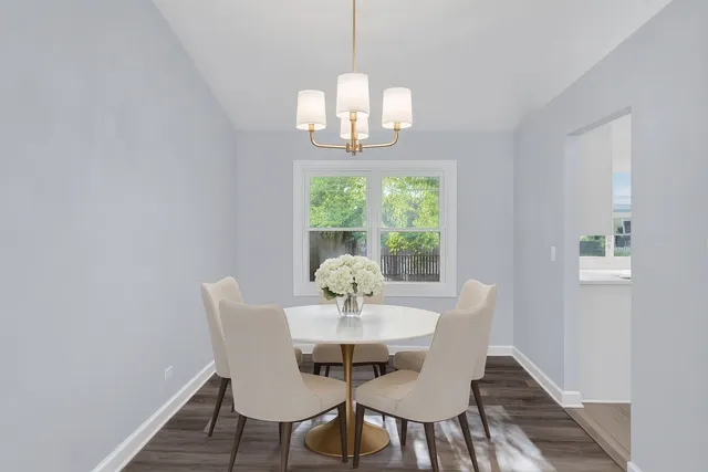 a dining room with furniture a chandelier and wooden floor