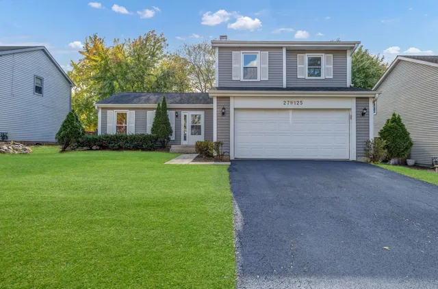 a view of a house with a yard and a garage