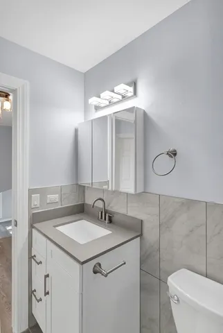 a bathroom with a sink vanity and toilet