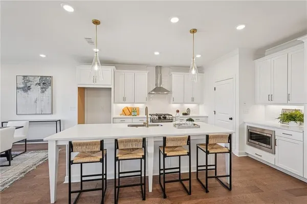 a kitchen with kitchen island a sink stove top oven and cabinets