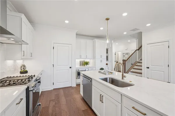 a kitchen with kitchen island a white counter top space a sink and cabinets