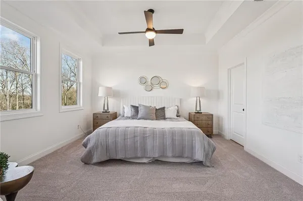 a spacious bedroom with a bed and a chandelier fan