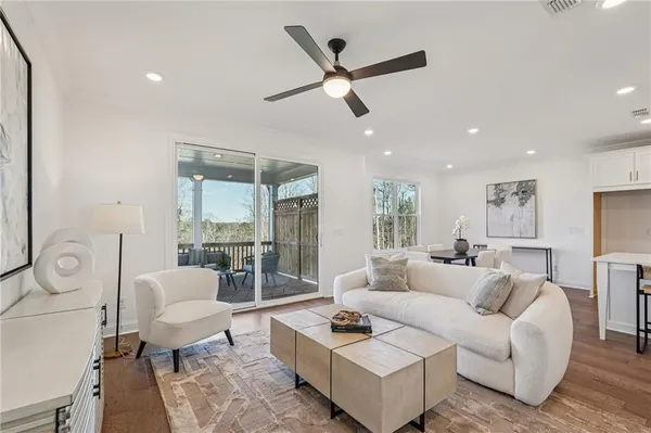 a living room with furniture and a large window with wooden floor