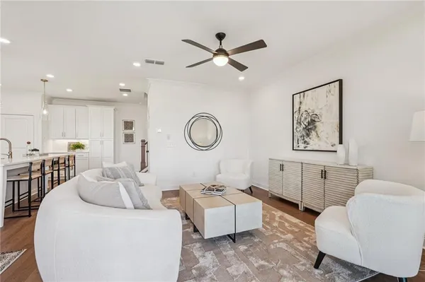 a living room with furniture a rug and a ceiling fan