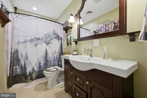 a bedroom with a large bed a flat tv screen and a dresser