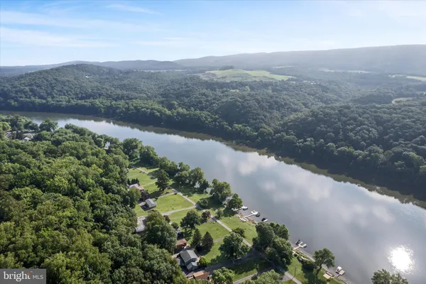 a wooden house with large trees and wooden fence