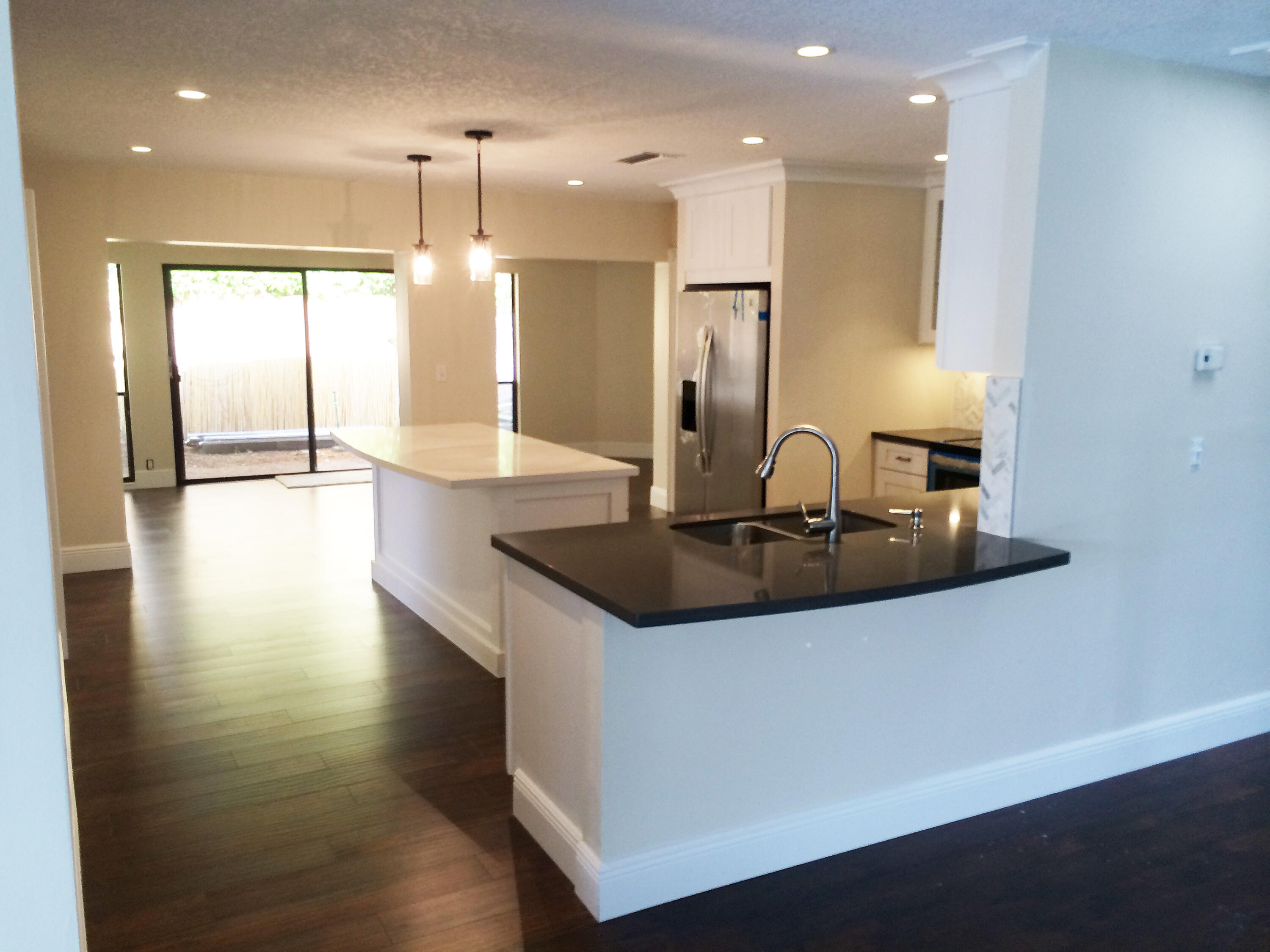 787 Northeast 32nd Street Boca Raton, FL 33431 - Photo 12 of 21 a kitchen with kitchen island granite countertop a sink and a refrigerator
