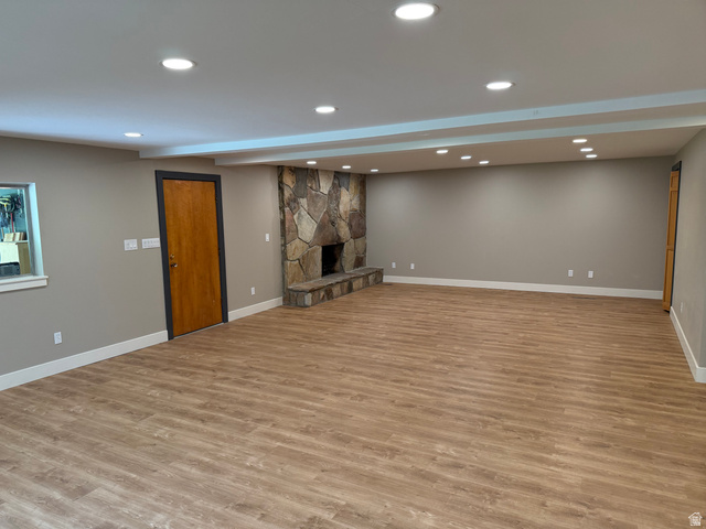 15 West 1600th Street South Mapleton, UT 84664 - Photo 12 of 22 Spacious room featuring a prominent stone fireplace with a raised hearth, wood-finish flooring, and recessed ceiling lighting