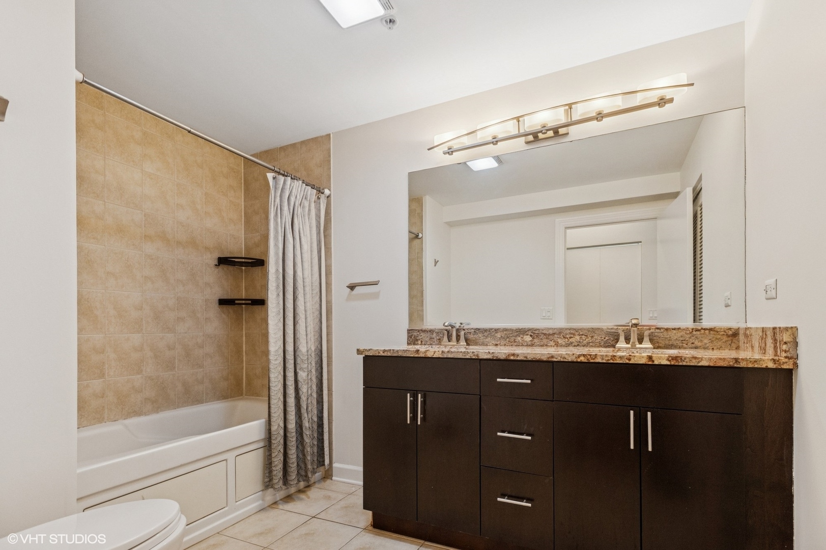 451 West Huron Street, Unit 910 Chicago, IL 60654 - Photo 18 of 27 a bathroom with a granite countertop sink mirror toilet and bathtub