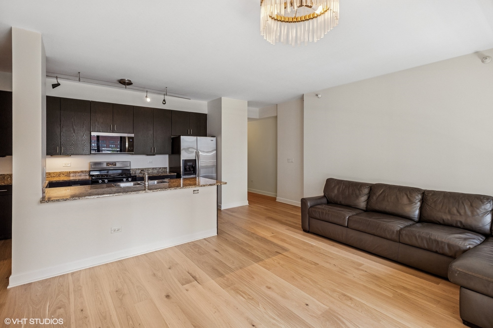 451 West Huron Street, Unit 910 Chicago, IL 60654 - Photo 22 of 27 a living room with stainless steel appliances kitchen island granite countertop a couch and a stove
