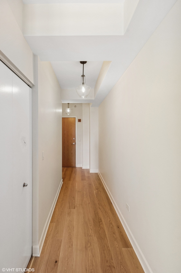 451 West Huron Street, Unit 910 Chicago, IL 60654 - Photo 23 of 27 a view of a hallway with wooden floor