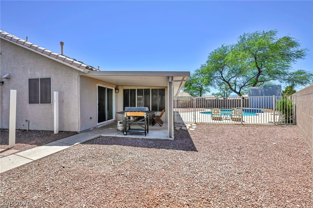 1234 Sunfire Street Henderson, NV 89014 - Photo 38 of 40 A spacious backyard retreat features a covered patio perfect for al fresco dining and a private, fenced pool.