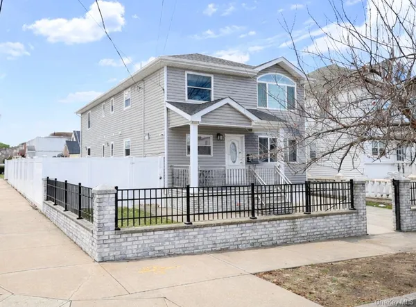 a view of a white house with iron fence