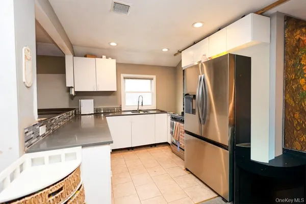 a large kitchen with stainless steel appliances granite countertop a refrigerator a sink and a stove