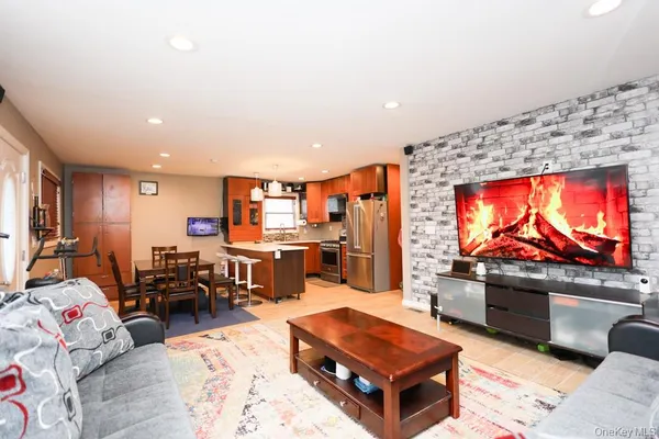 a living room with furniture a flat screen tv and floor to ceiling window