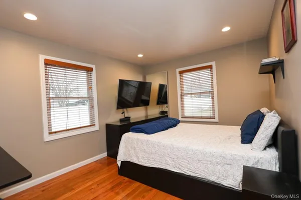 a bedroom with a bed tv and window