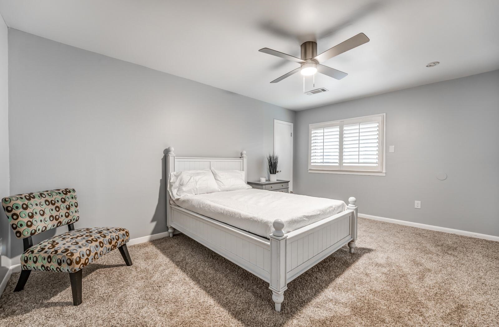 3089 Charles Bryan Road Bartlett, TN 38134 - Photo 16 of 28 a white bed sitting in a bedroom next to a window with a chandelier