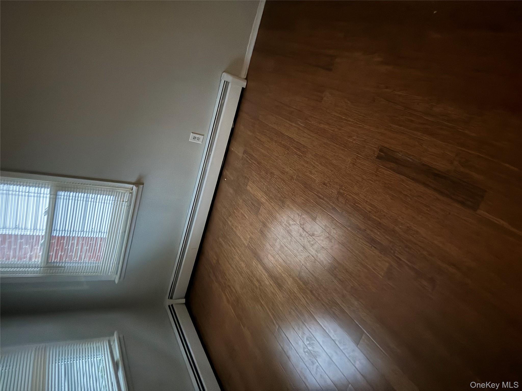 18 Leach Street Lynbrook, NY 11563 - Photo 12 of 17 an empty room with wooden floor and windows