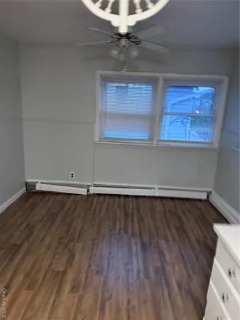 a view of a room with wooden floor and white walls