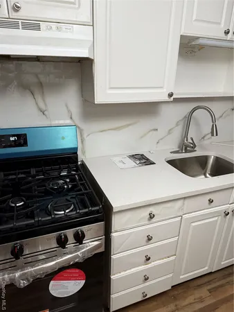 a stove top oven sitting inside of a kitchen