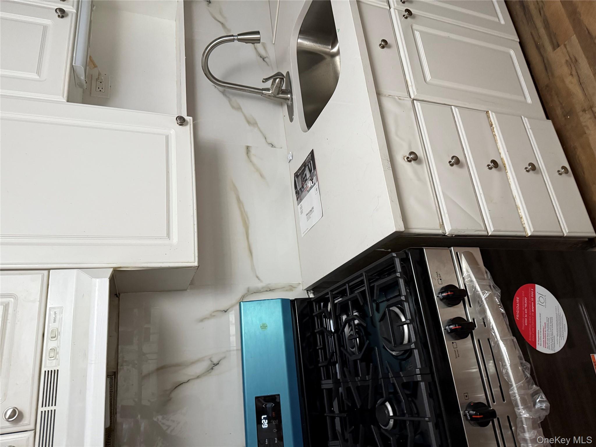 18 Leach Street Lynbrook, NY 11563 - Photo 5 of 17 a stove top oven sitting inside of a kitchen
