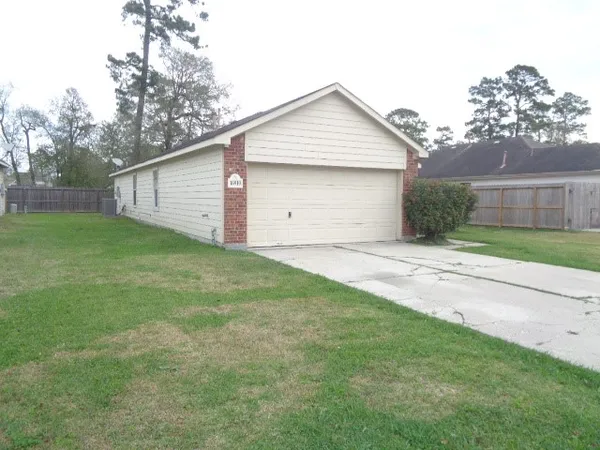 a front view of house with yard and trees all around