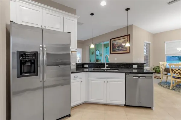 a kitchen with kitchen island granite countertop a stove a sink a microwave a dining table and chairs with wooden floor