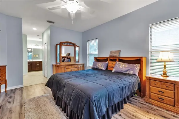 a bedroom with a bed and a bookshelf with wooden floor