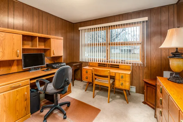 a view of a workspace with furniture and a window