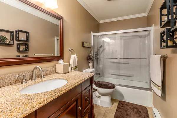 a bathroom with a granite countertop sink toilet and shower