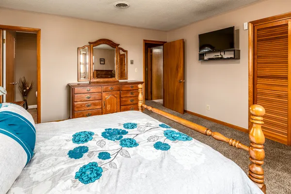 a bedroom with a bed and a flat screen tv