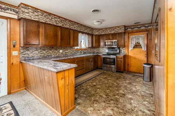 a kitchen with stainless steel appliances granite countertop a sink stove and refrigerator