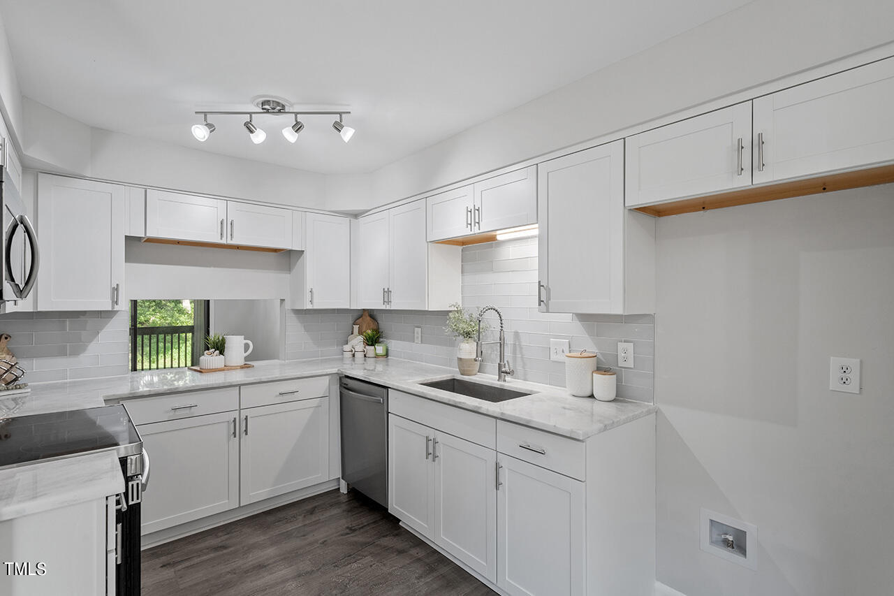 4100 Five Oaks Drive, Unit 46 Durham, NC 27707 - Photo 1 of 36 a kitchen with a sink dishwasher and white cabinets with wooden floor