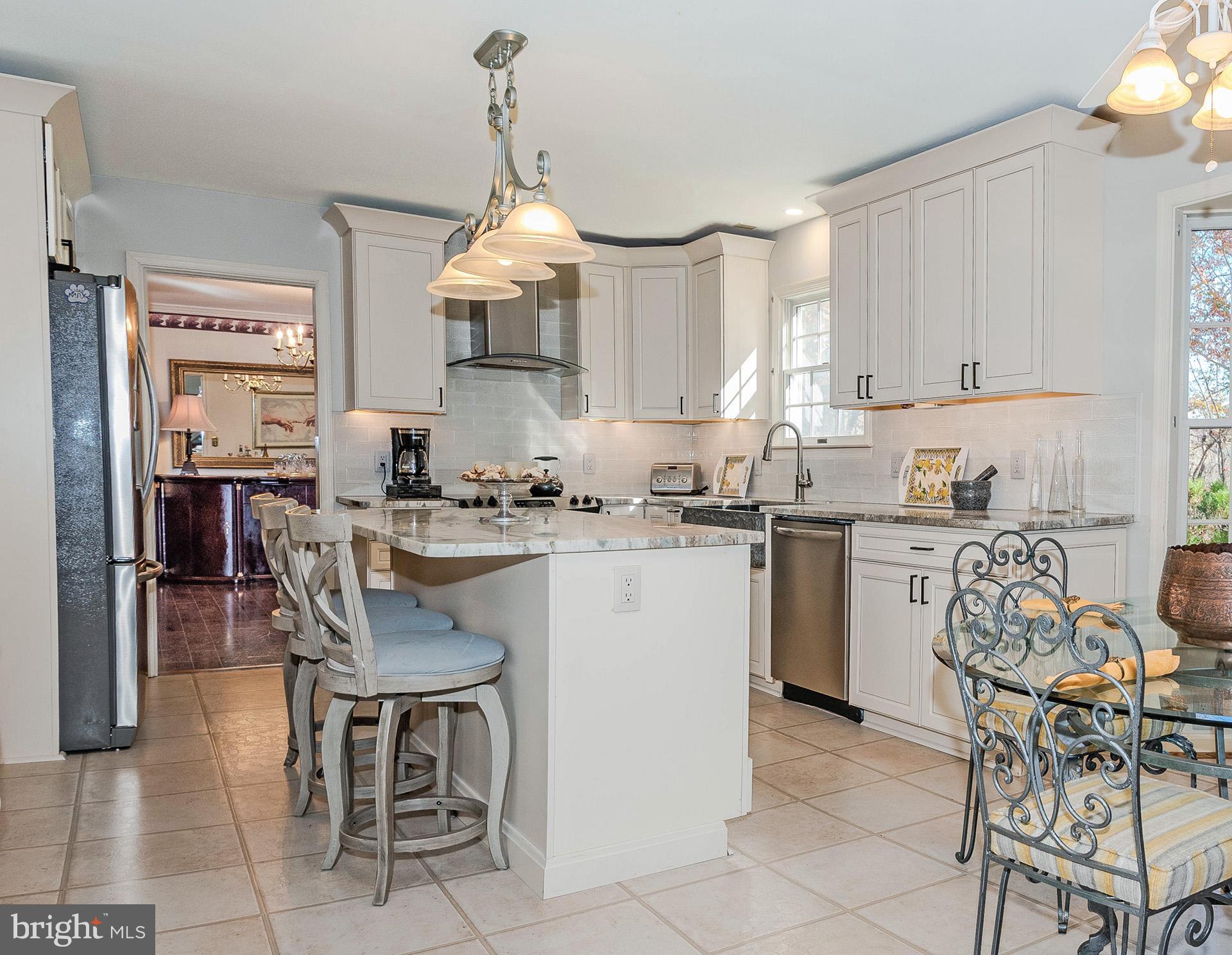 621 Wood Lot Trail Road Annapolis, MD 21401 - Photo 15 of 44 a kitchen with granite countertop a table chairs stove and refrigerator